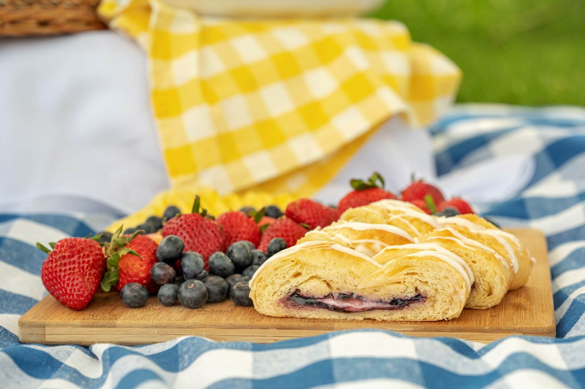 Strawberry and Cream Cheese Butter Braid Pastry with slice on plate next to fork and whole strawberries